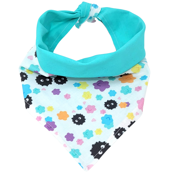 front view of a handmade Studio Ghibli dog bandana or handmade Studio Ghibli cat bandana featuring black soot sprites among colorful flowers; this pattern is called Soot Sprites